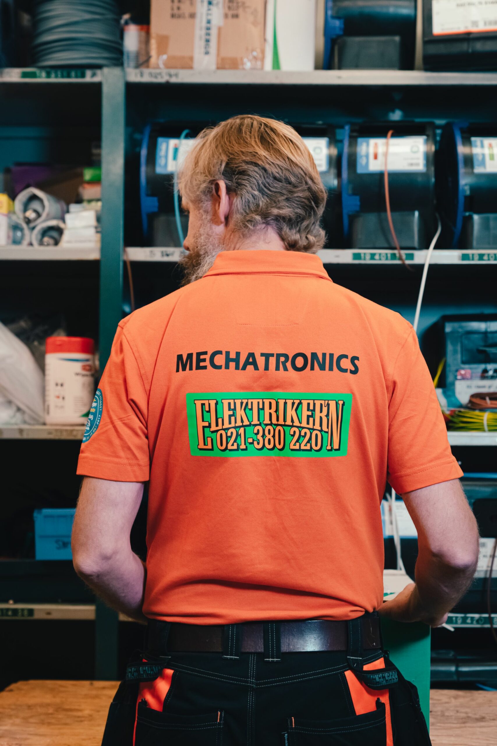 Porträtt på Jimmy Wilhelmsson med en pike tröja som det står Elektrikern på